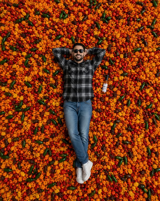 Jason lying in a giant pile of chillies